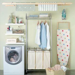 room with washing machine and clothes on hangers