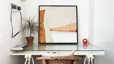 Rust abstract canvas art leaning on desk in bedroom