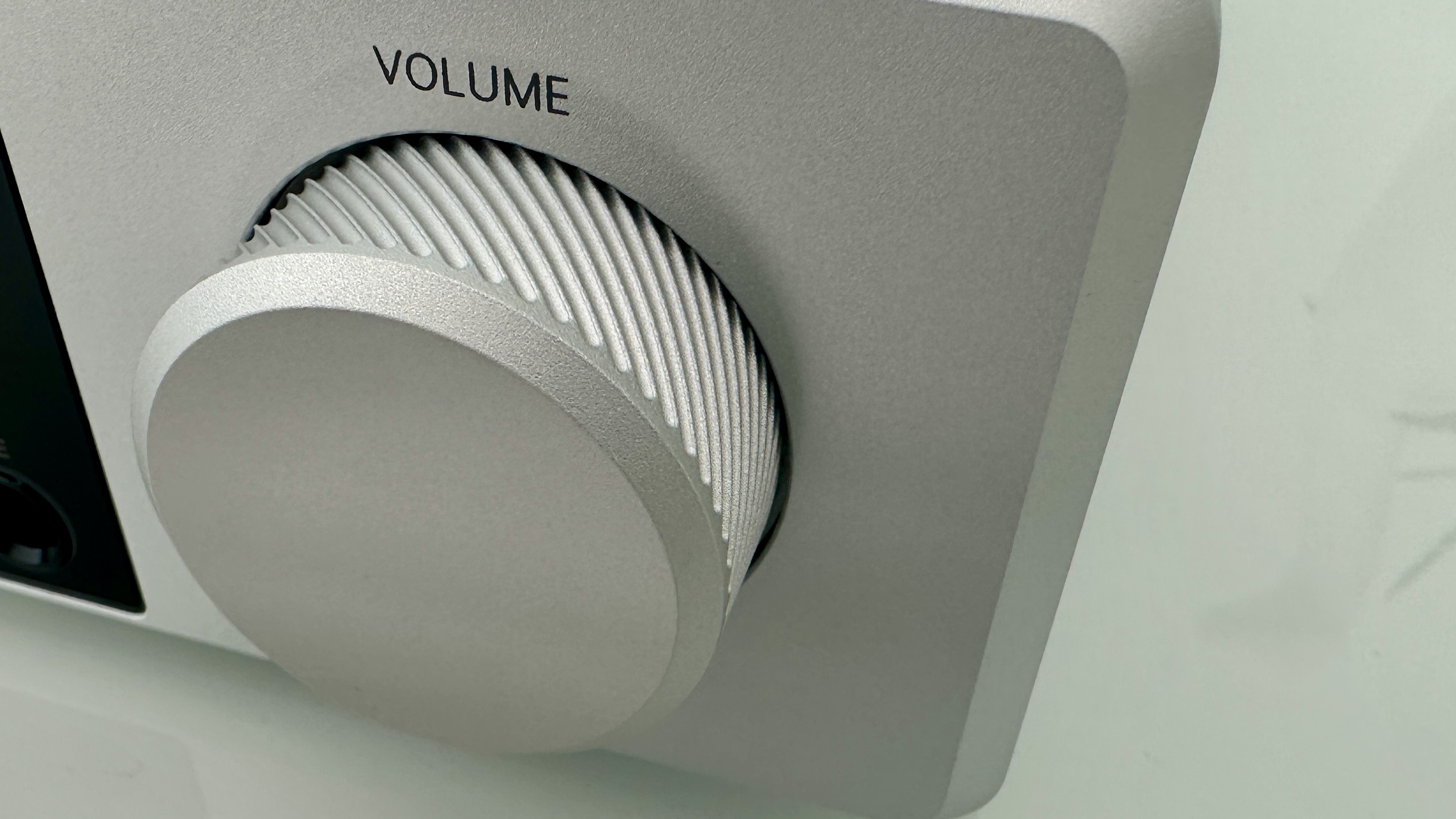 Rotel's DX-5 integrated amp in silver on a light gray table, with the amp's remote visible