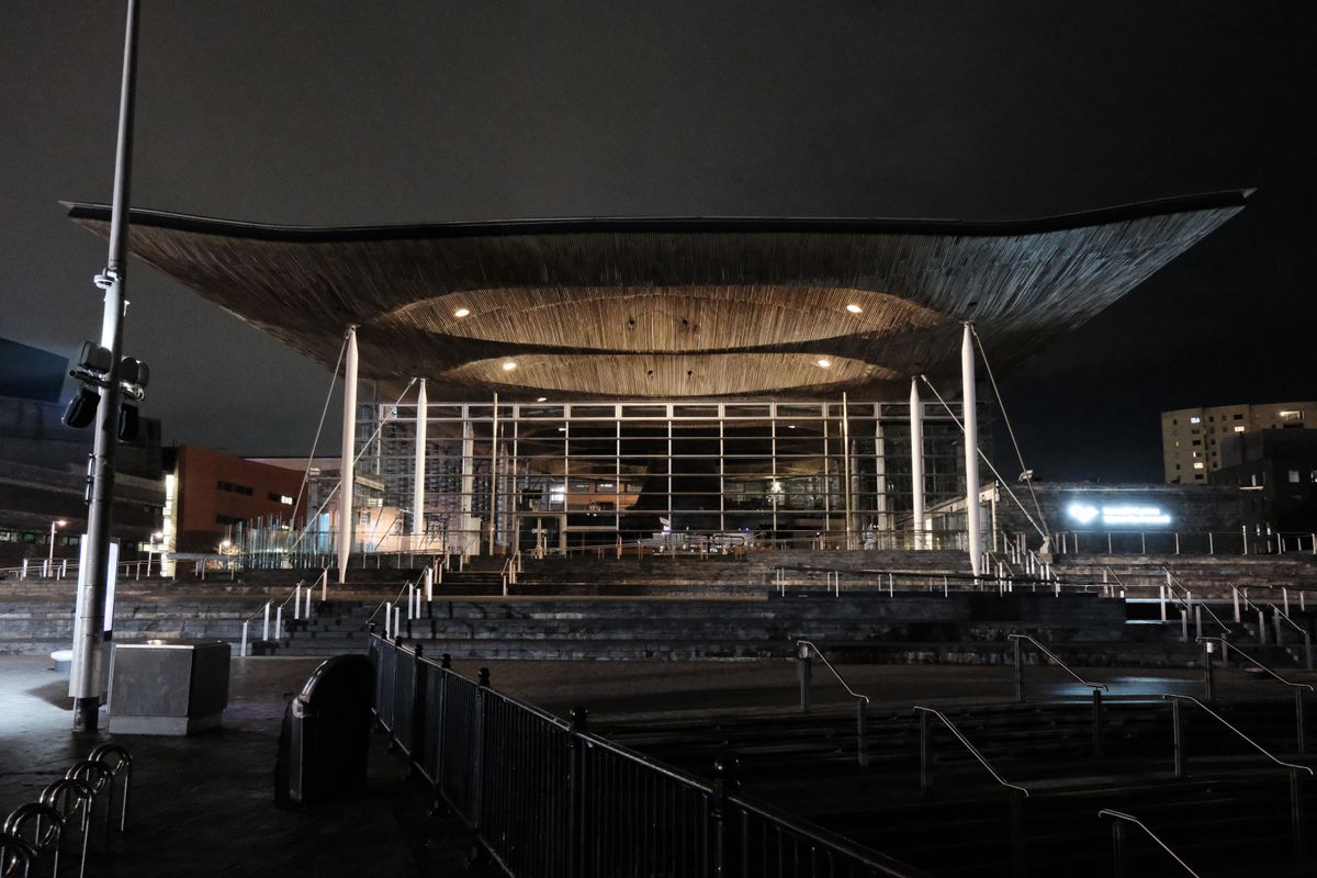 A photo of the Cardiff Senedd building, taken at night.
