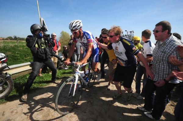 Tom Boonen (Quick Step) is helped back into his bike following a puncture in the Arenberg forrest