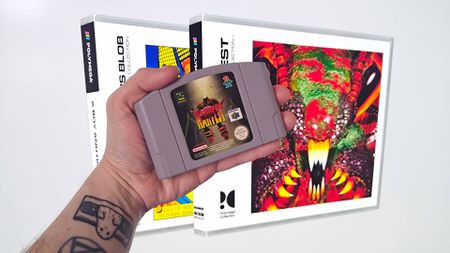 Hand holding N64 game Body Harvest with new Polymega CD releases in backdrop.