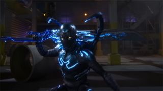 Still from the movie Blue Beetle (2023). Blue Beetle holding large buster-style sword.