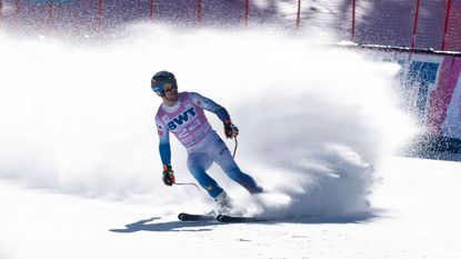 Photo of man skiing with a puff of snow behind him