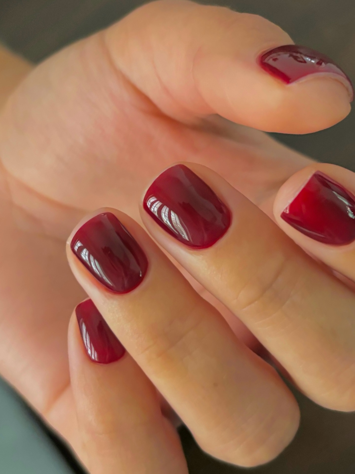 a close up of a cranberry manicure on short nails