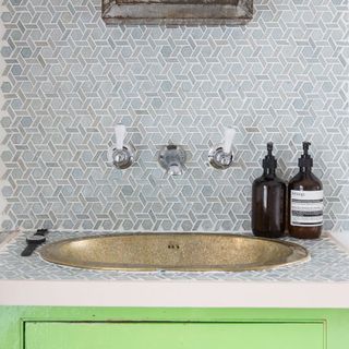 family bathroom with gold sink and statement wall tiles