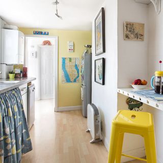 white kitchen with worktop and yellow chair