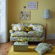 living room with rug o floor and sofa with cushion and yellow wall