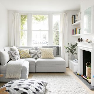 White living room with grey sofa and spotted floor cushion