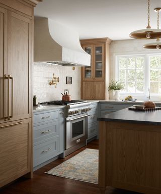 A blue wood and white kitchen with a tiled backsplash and a kitchen rug in front of the range cooker