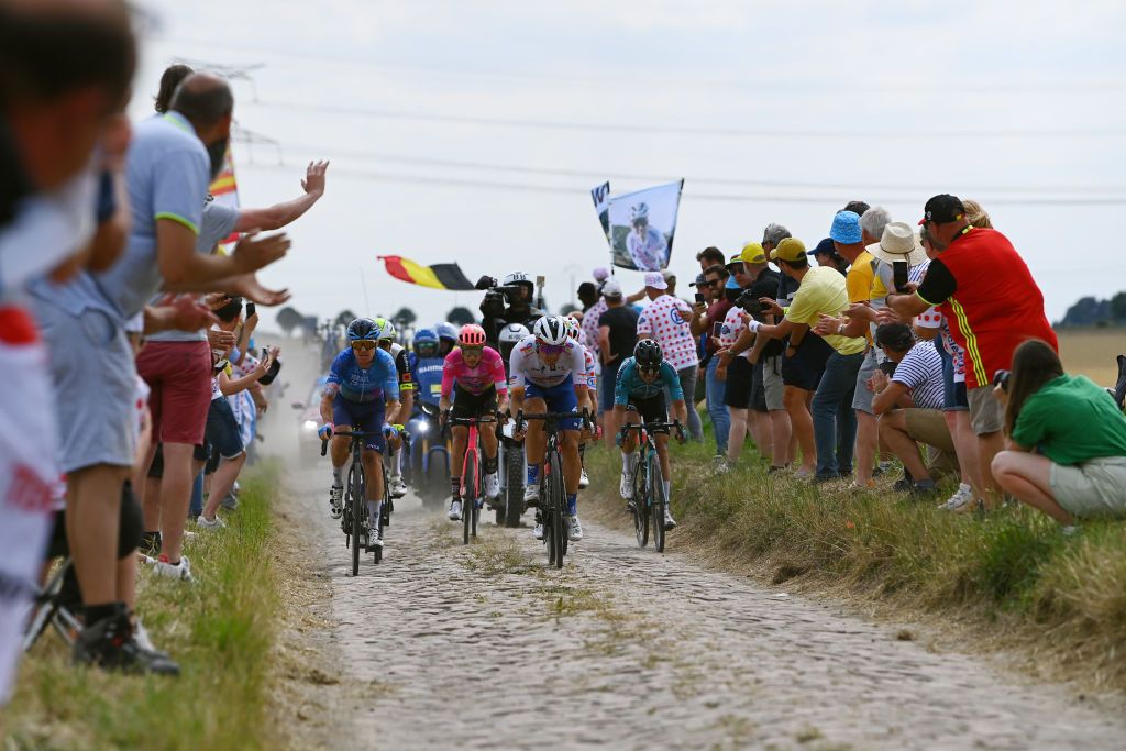 WALLERS FRANCE JULY 06 LR Simon Clarke of Australia and Team Israel Premier Tech Neilson Powless of United States and Team EF Education Easypost Edvald Boasson Hagen of Norway and Team Total Energies and Alexis Gougeard of France and Team BB Hotels PB KTM compete in the breakaway passing through a cobblestones sector while fans cheer during to the 109th Tour de France 2022 Stage 5 a 157km stage from Lille to WallersArenberg TDF2022 WorldTour on July 06 2022 in Wallers France Photo by Tim de WaeleGetty Images