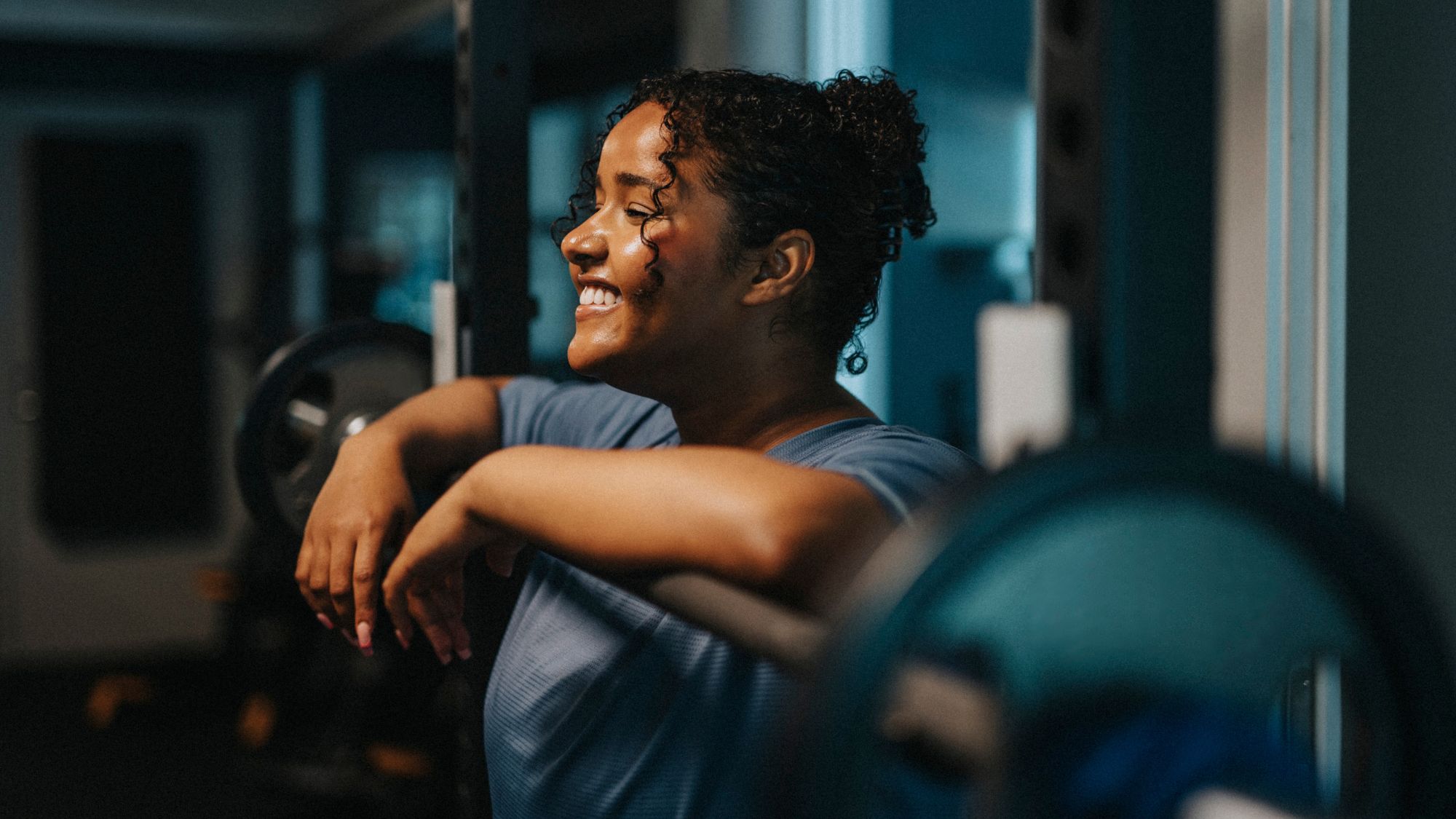 How to structure your weights sessions: a woman stood by a barbell at a gym mid-workout