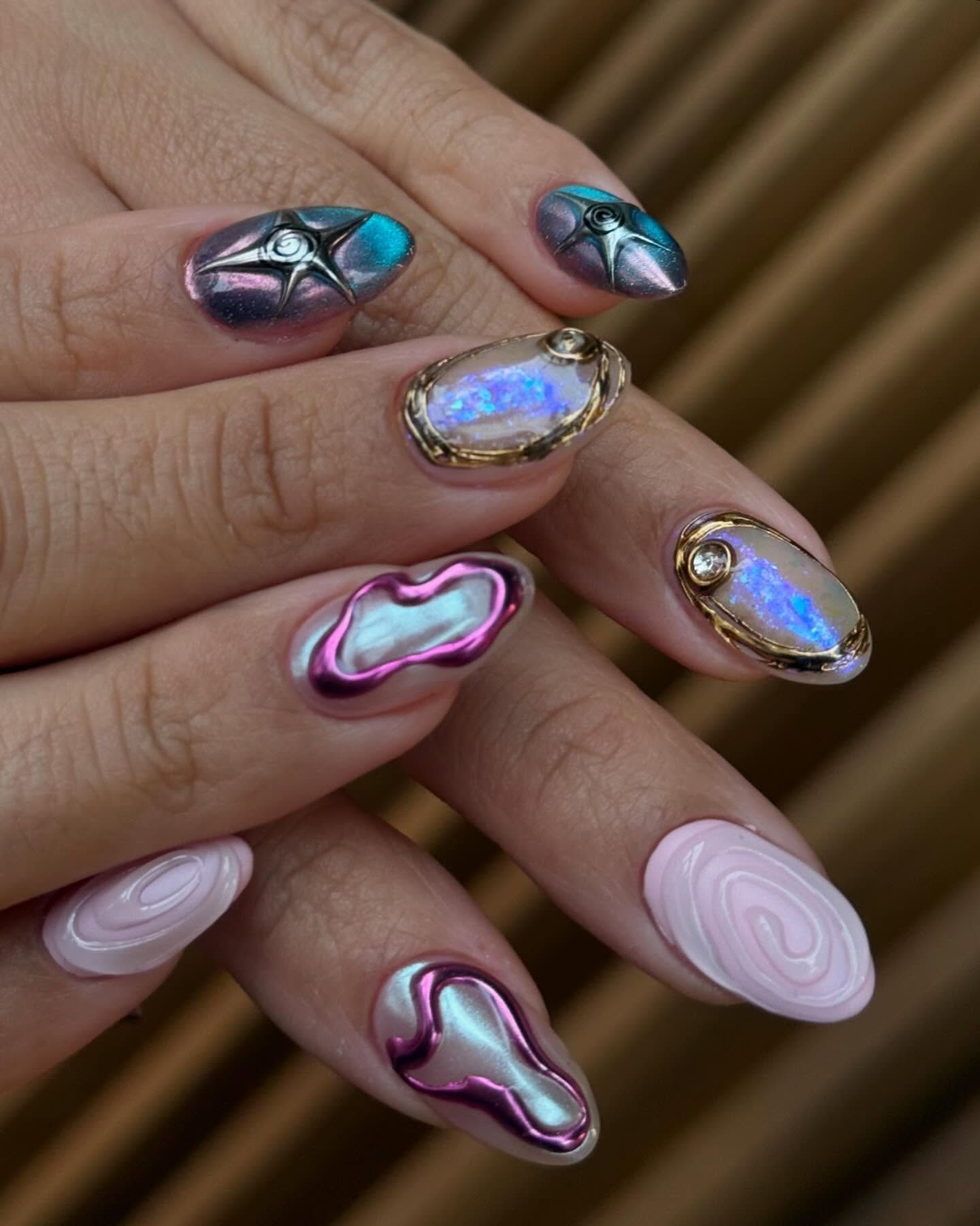 A close-up picture of a colourful, bedazzled, 3D manicure