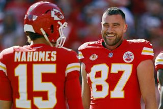 Travis Kelce #87 and Patrick Mahomes #15 of the Kansas City Chiefs talk before the game against the Los Angeles Chargers at GEHA Field at Arrowhead Stadium on October 22, 2023 in Kansas City, Missouri.