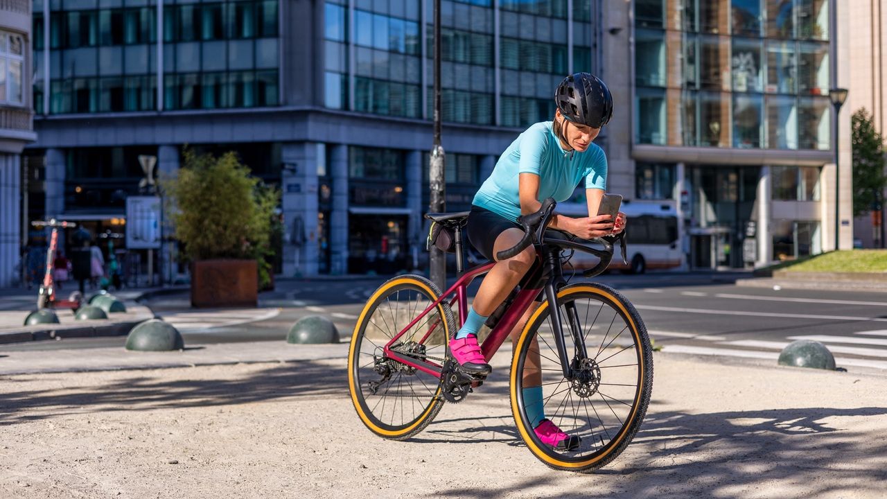 A stationary cyclist looking at her mobile phone