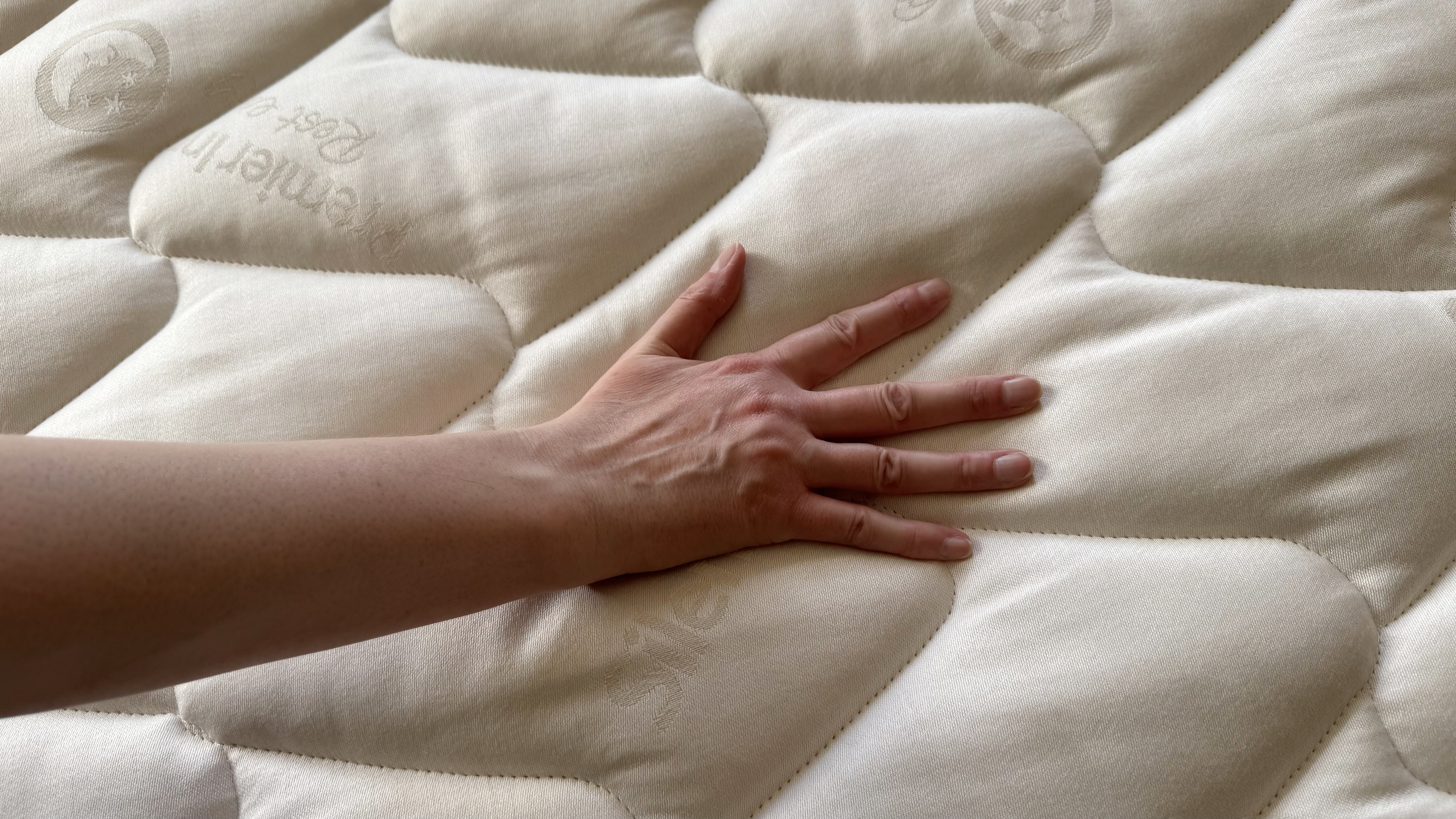 A hand pressing on the Premier Inn mattress