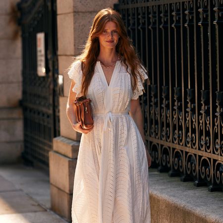 fashion week attendee wearing white eyelet dress and brown bag