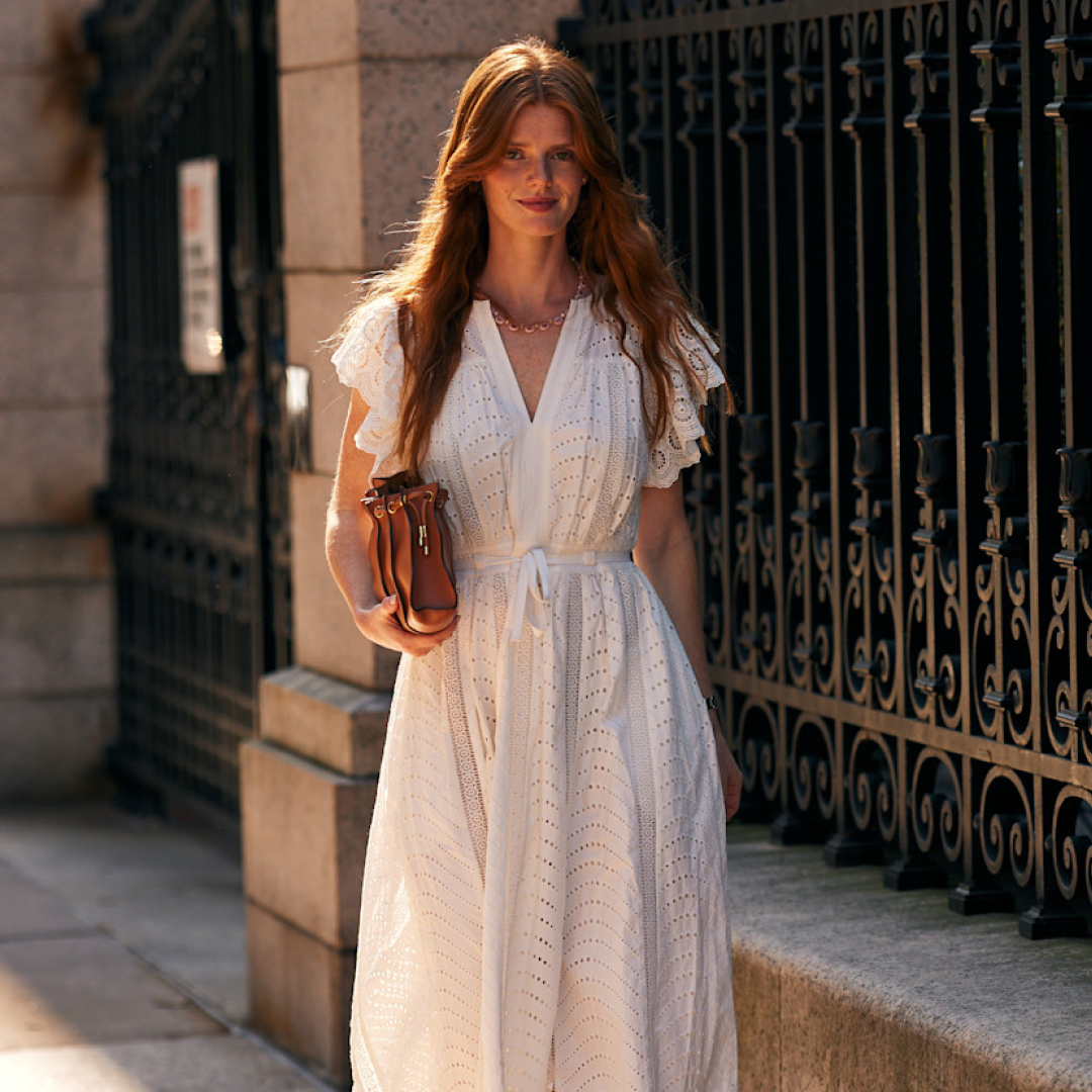 fashion week attendee wearing white eyelet dress and brown bag