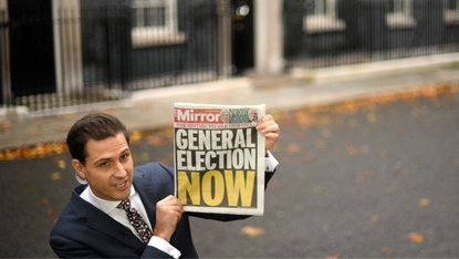 Journalist holds frontpage reading 'General Election Now' outside of No. 10 Downing Street