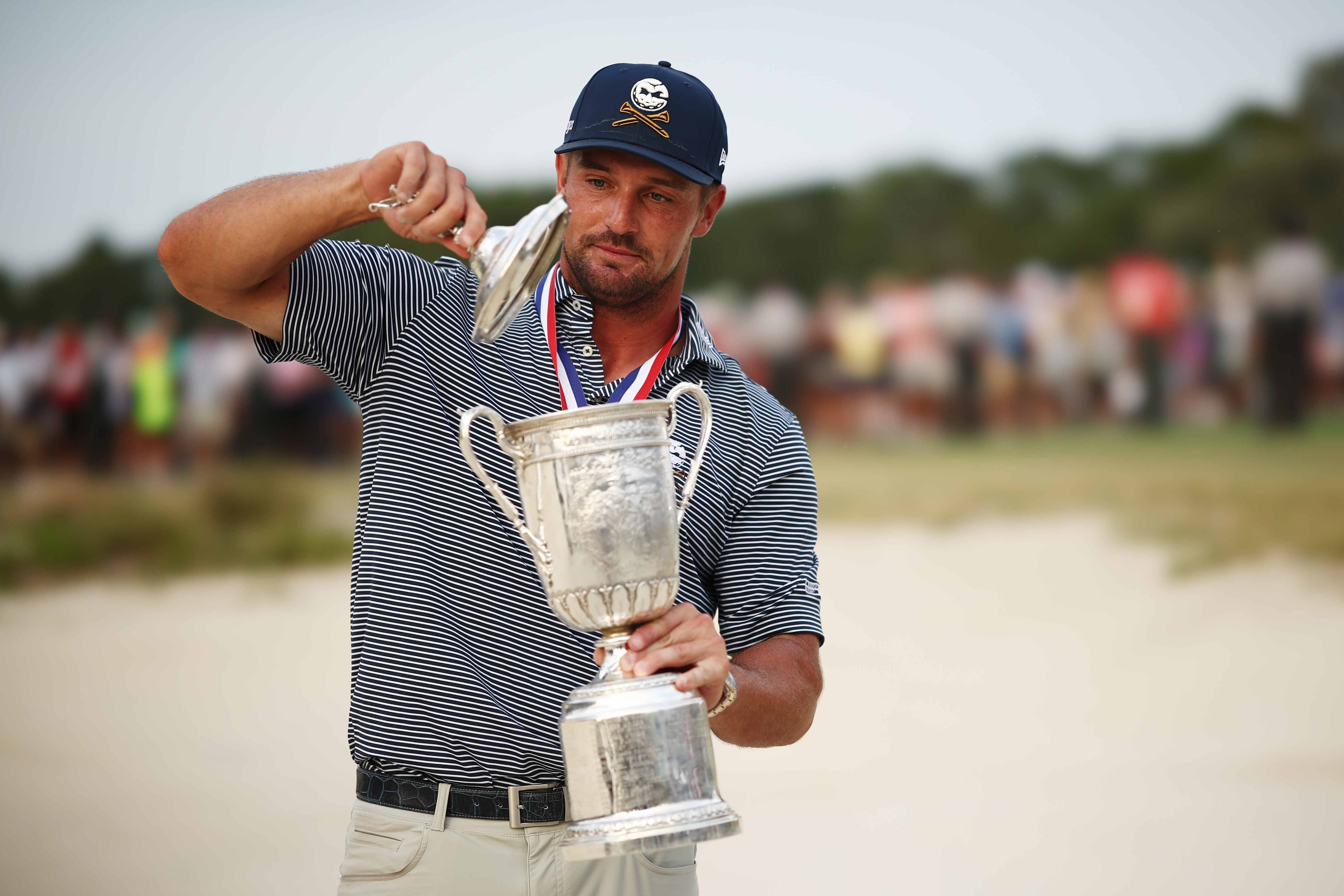 Bryson DeChambeau takes the lid off the US Open trophy after his win in 2024