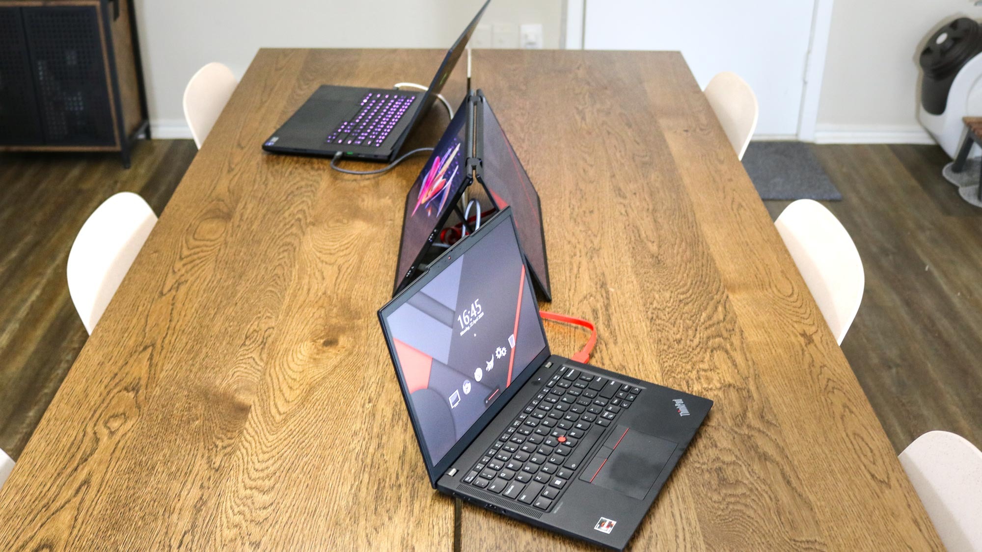 Two laptops connected to the UPERFECT UStation Delta in tent mode on a kitchen table