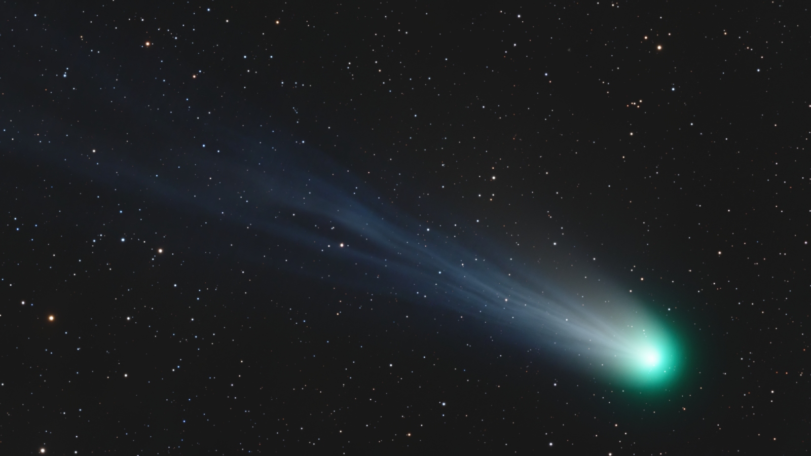 A green comet streaking across the night sky