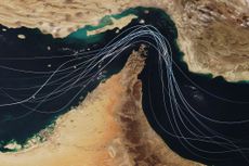 Satellite view of the Strait of Hormuz with white graphic lines representing global shipping lanes and maritime traffic between the Persian Gulf and Gulf of Oman