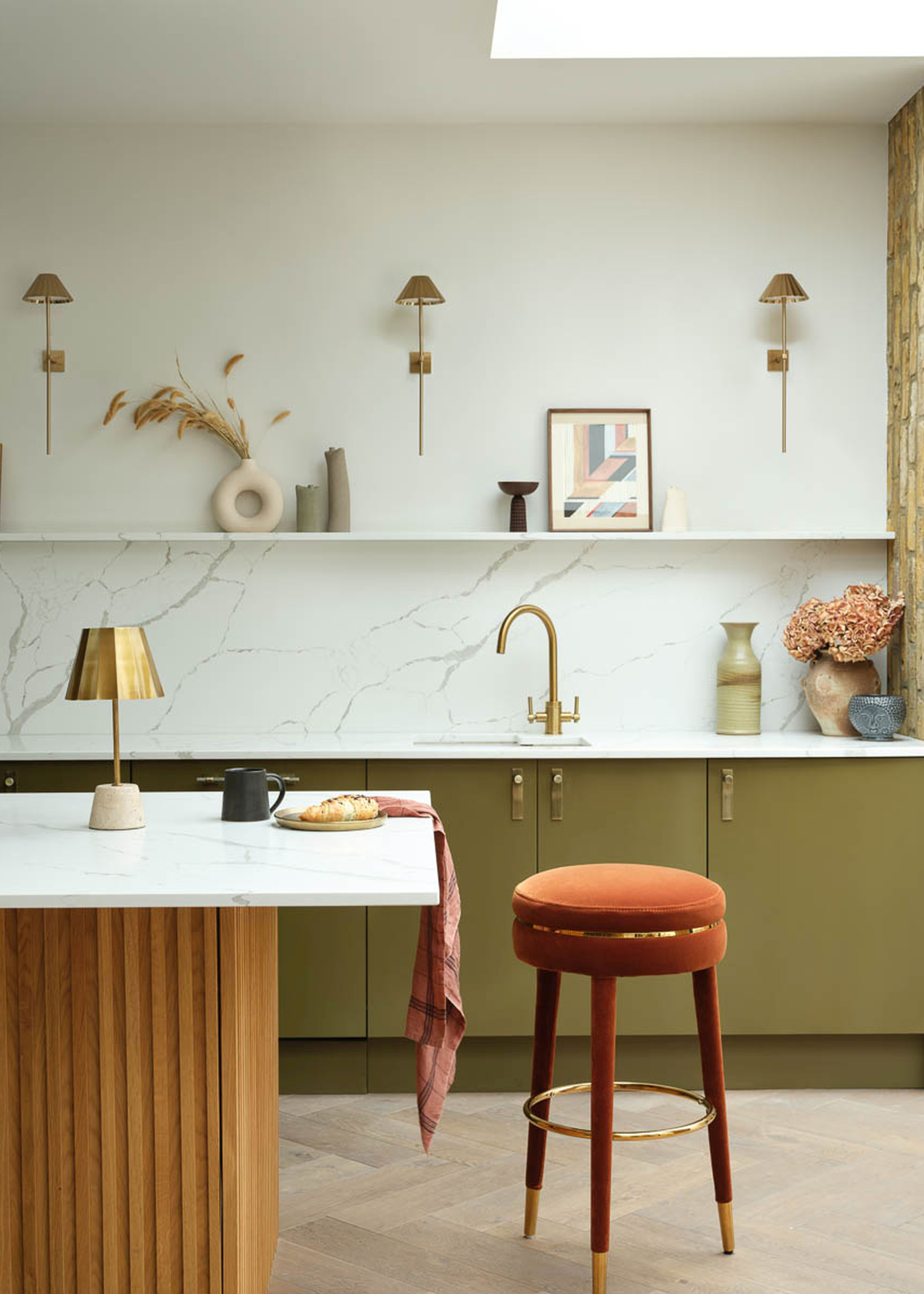 a modern kitchen with green cabinets and wall lights