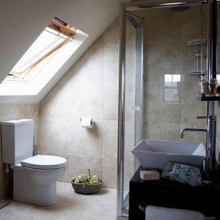 Loft bathroom with beige wall and floor tiles and glass shower