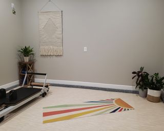 a home gym with gym machine, workout mat and plants - Kristine B