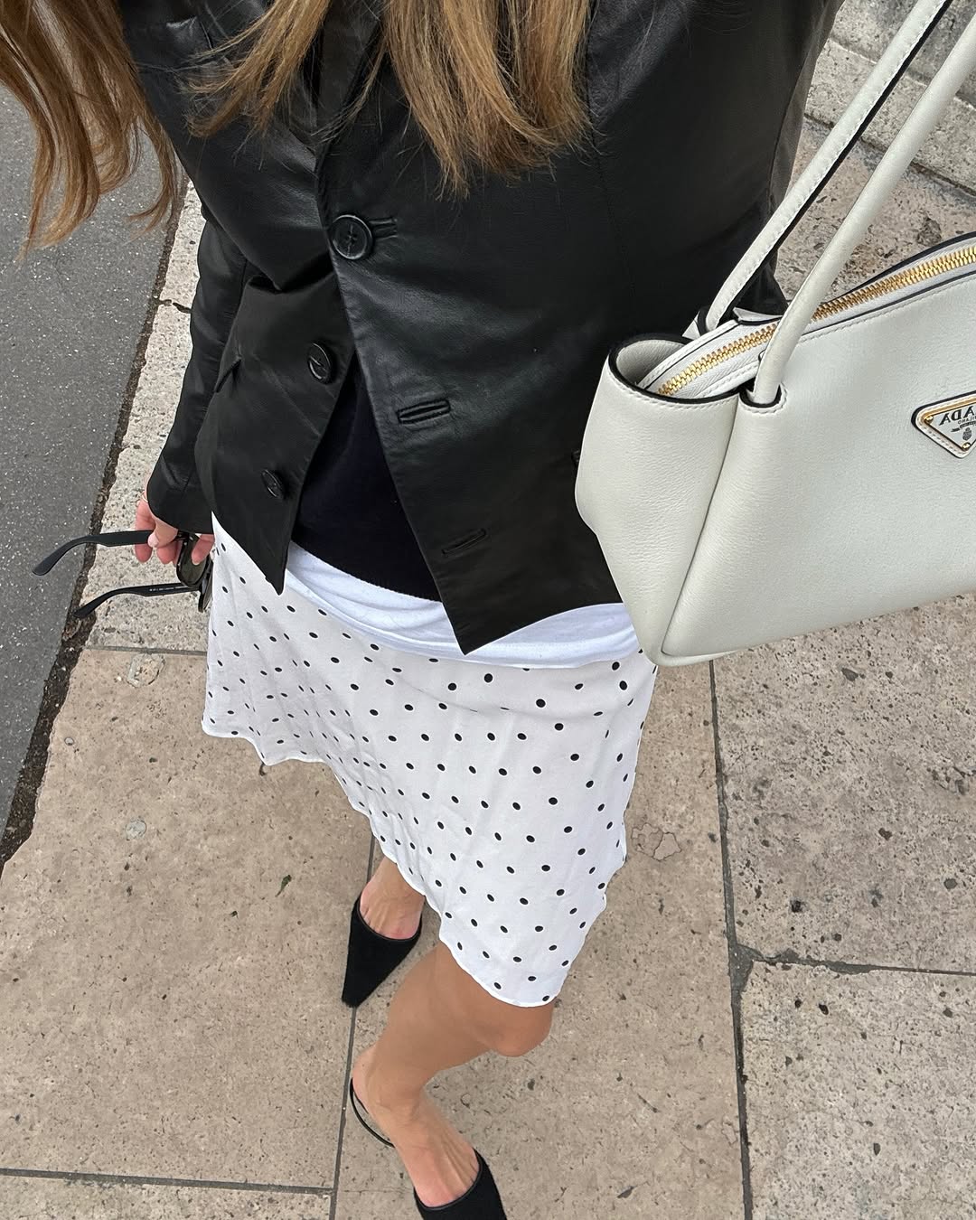 Woman wearing knee-length skirt outfit summer 2025.