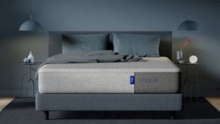 The Casper Original Mattress placed on a grey fabric bed frame in a dusky blue bedroom