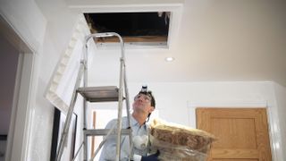 Man insulating a loft hatch on a DIY basis