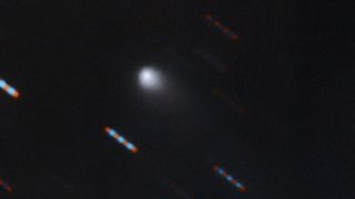 The first color image of the comet C/2019 Q4 (Borisov), which astronomers believe was born in another solar system, was captured by the Gemini North telescope at Hawaii's Mauna Kea. Gemini North acquired four 60-second exposures in two color bands (red and green). The blue and red lines are stars moving in the background.
