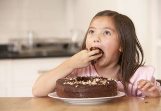 Child eating chocolate cake