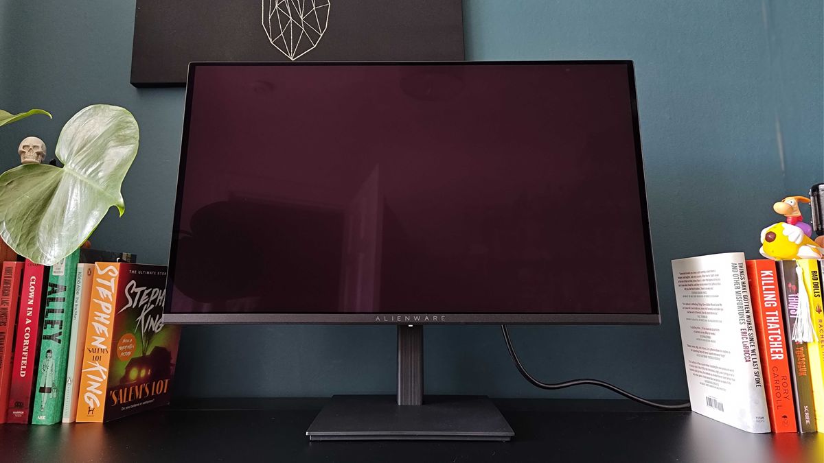 Alienware AW2726DM on black desk with screen off.