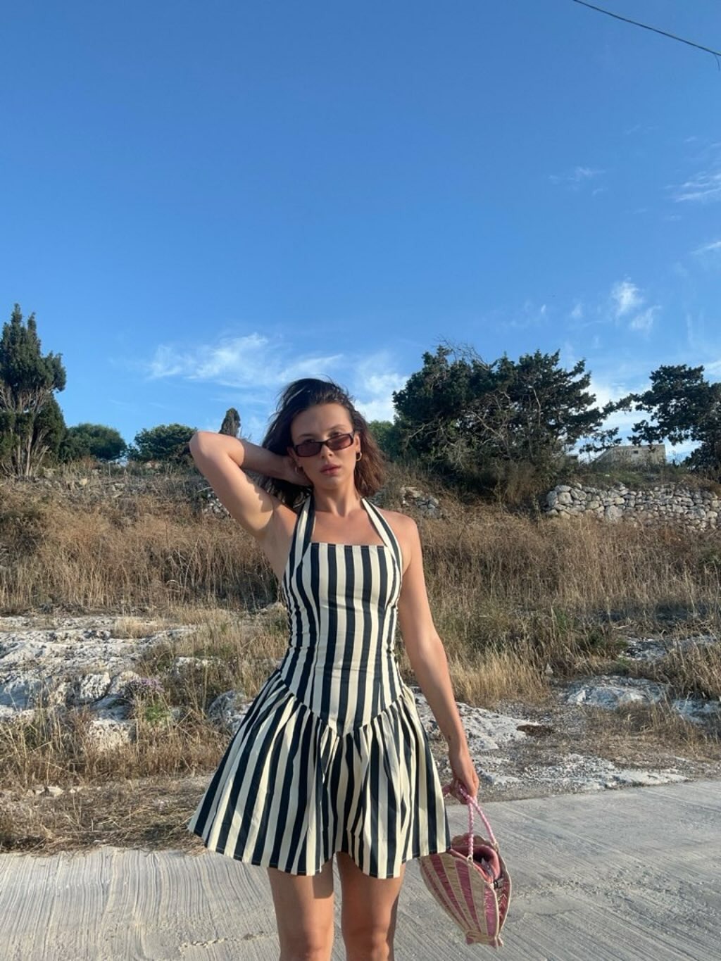 Millie Bobby Brown wears a black-and-white striped dress on the beach in Malta.