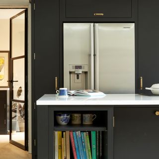 Kitchen with dark colour scheme, fridge, island, and cabinets