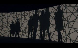 A black silhouette of people standing in a group.