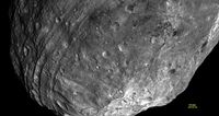 Vesta used to be round—until it got hit by something nearly one-tenth its size. The resulting impact basin, named Rheasilvia, fills most of this image, taken from some 5,200 kilometers away. Vesta’s south pole lies in the mountains at lower right, while the parallel grooves at left (also created by the impact) run roughly along the equator. 