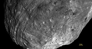 Vesta used to be round—until it got hit by something nearly one-tenth its size. The resulting impact basin, named Rheasilvia, fills most of this image, taken from some 5,200 kilometers away. Vesta’s south pole lies in the mountains at lower right, while the parallel grooves at left (also created by the impact) run roughly along the equator. 