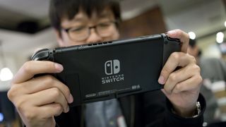 Man playing with a Nintendo Switch video game console.