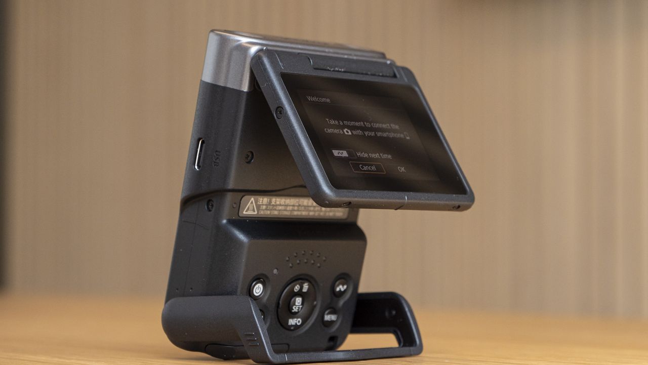 Canon Powershot V10 on a table with flipup screen partly out
