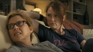 Annette Bening and Julianne Moore looking over while sitting on the couch in The Kids Are All RIght.