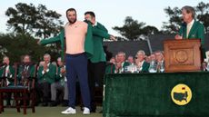 Scottie Scheffler receives the Green Jacket from Jon Rahm
