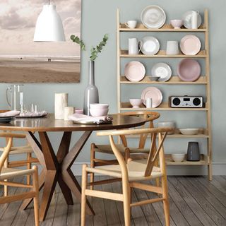 dinning table with chair plates wooden flooring and painting on wall