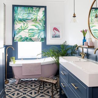 bathroom with blue panelling, pink bath and botanical blinds