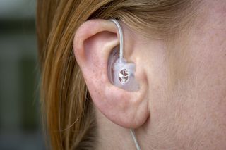 An earbud-type device in someone's ear.