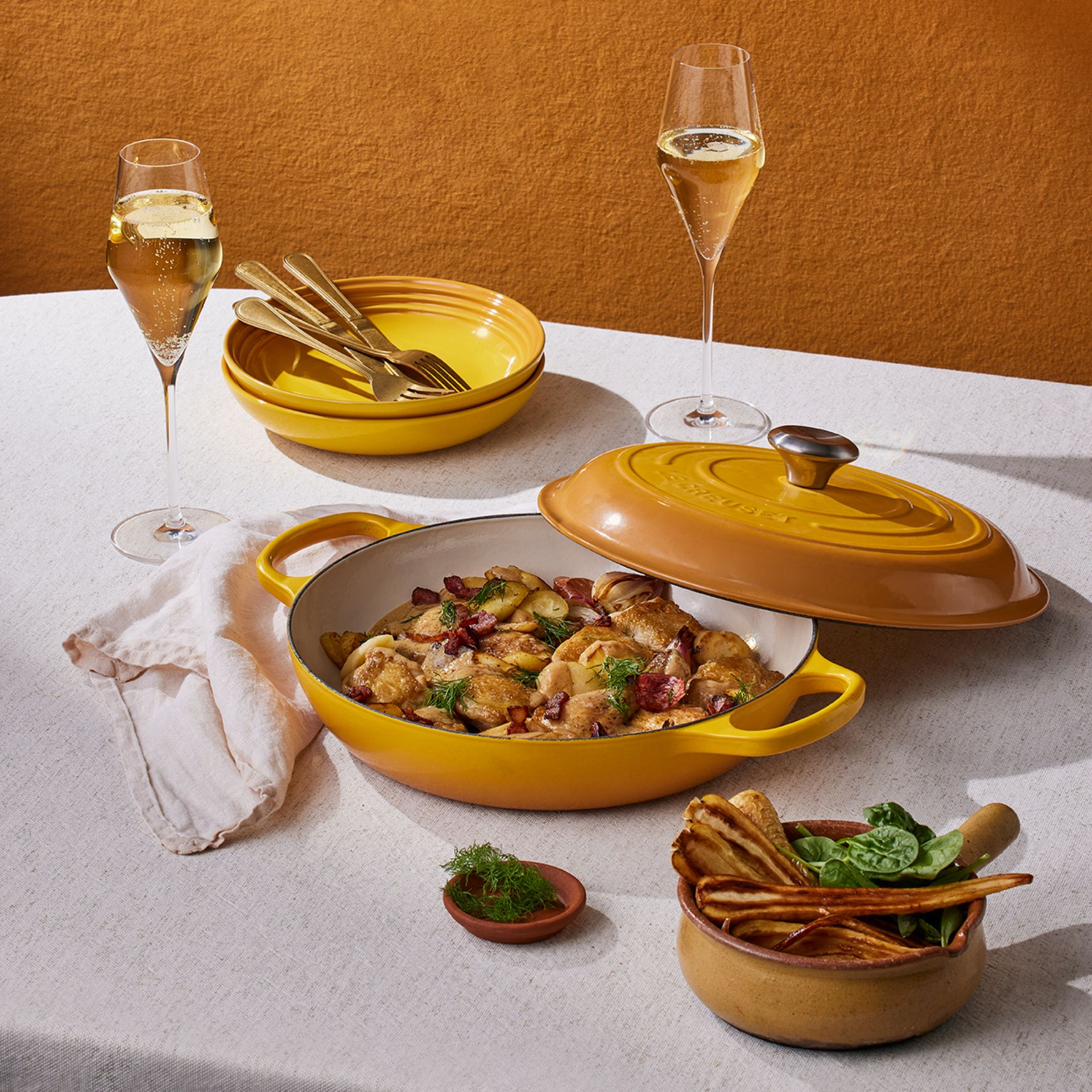 Yellow cast iron pot and dinnerware on table