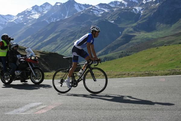 Alberto Contador is chased up the climb by a film crew